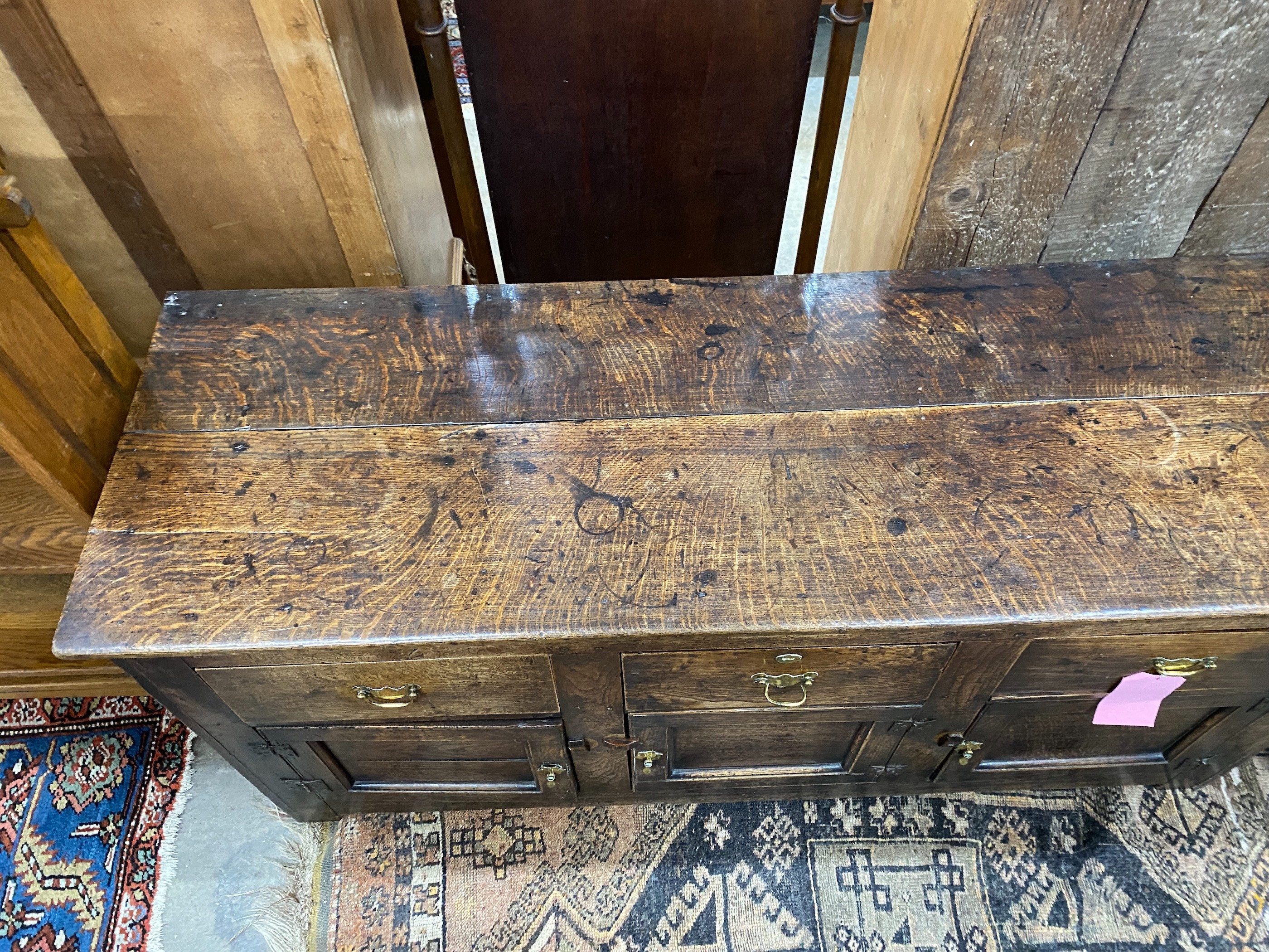 A late 18th century oak low dresser, the frieze with a small later added drawer, length 157cm, depth 52cm, height 75cm